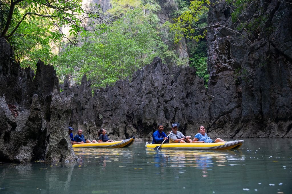 Canoes gliding into the hidden lagoon ringed by limestone walls at Koh Hong, Phang Nga Bay