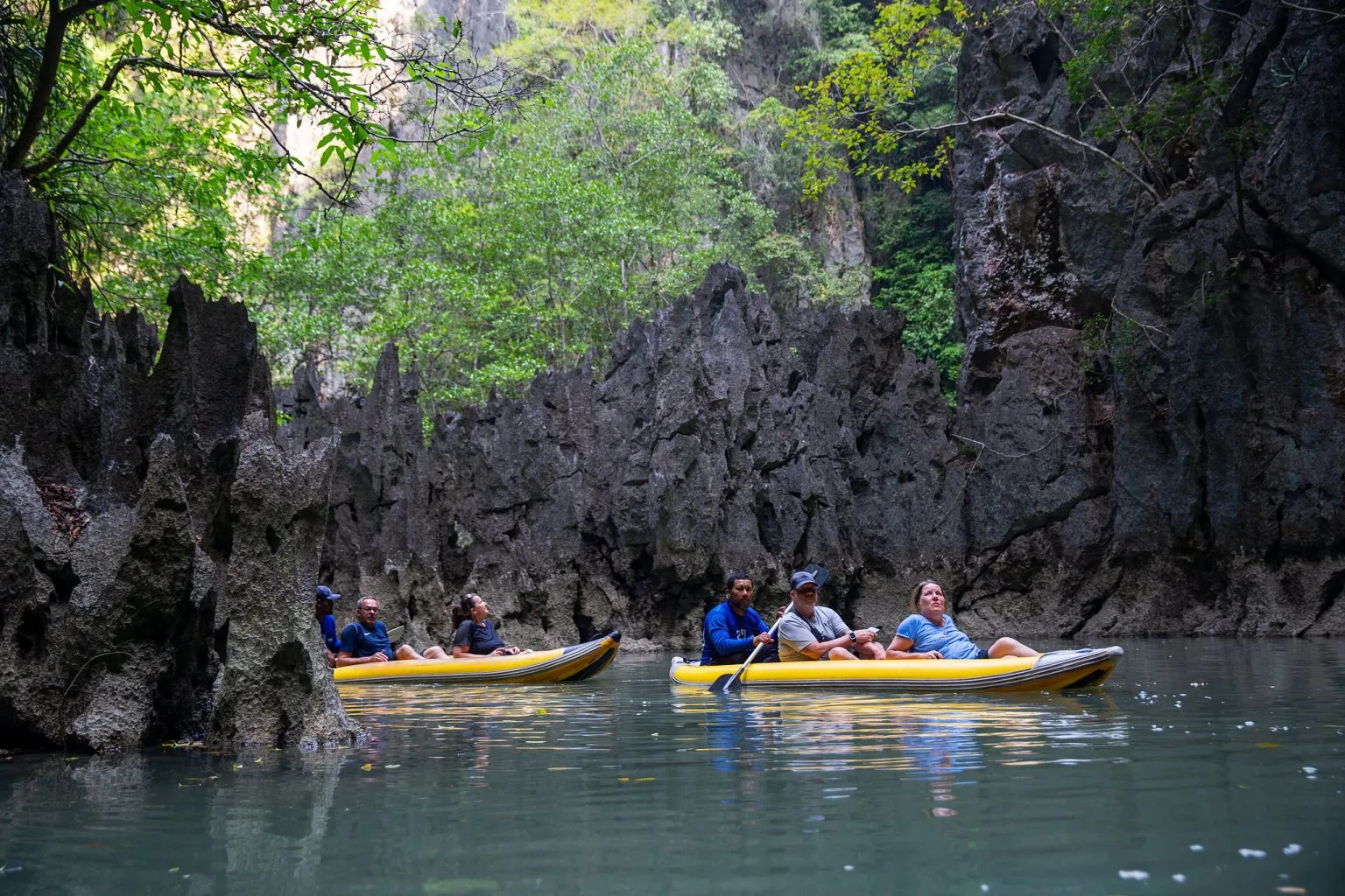 Canoes gliding into the hidden lagoon ringed by limestone walls at Koh Hong, Phang Nga Bay