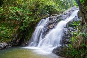 Dschungelwasserfall stürzt über Felsblöcke am Ende der Regenwaldwanderung bei Khao Lak