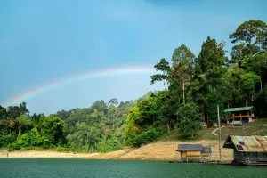 Regenbogen über dem Dschungel und schwimmenden Floßhaus-Bungalows auf dem Cheow-Lan-See, Khao Sok