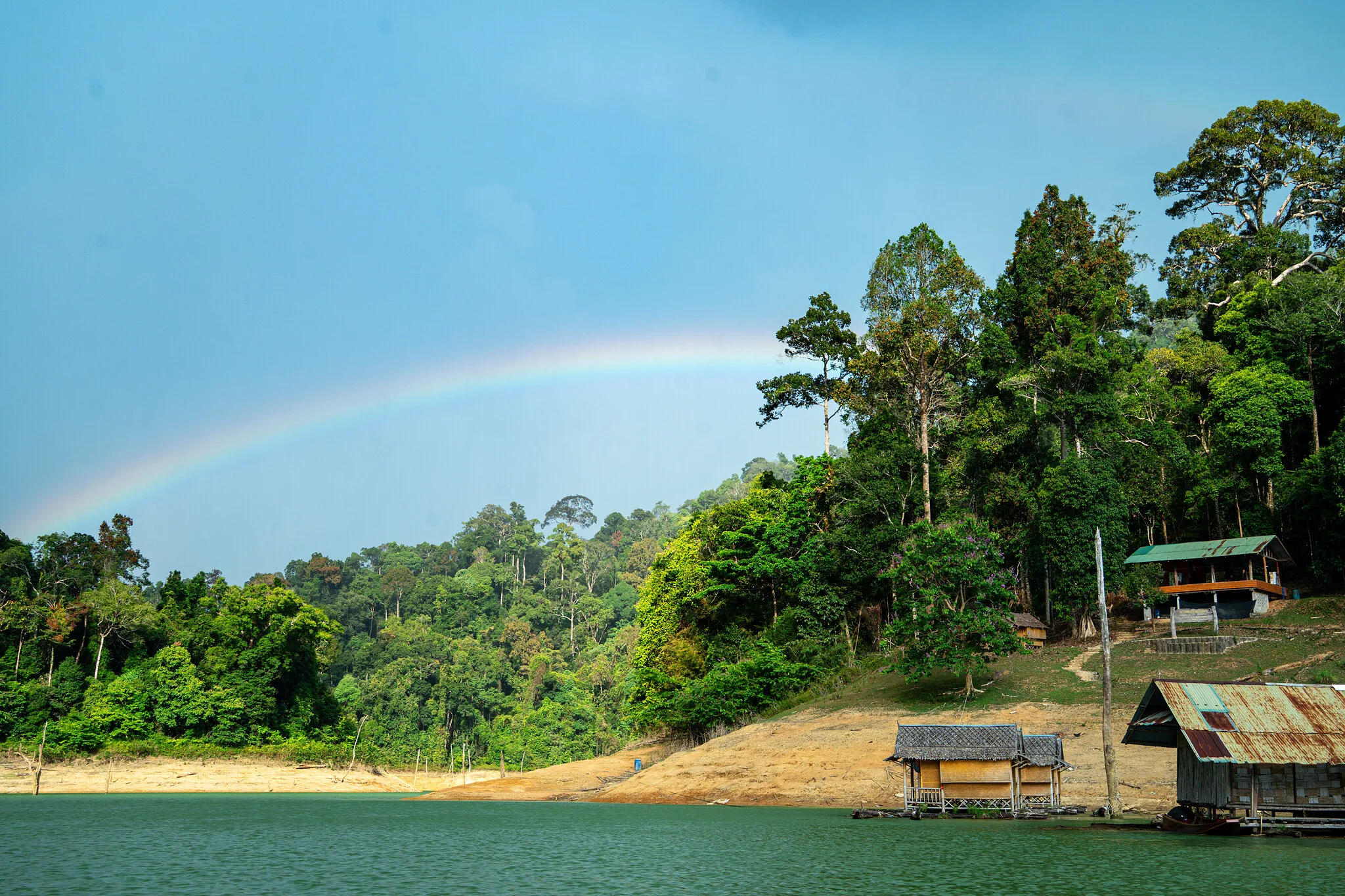 Regenbogen über dem Dschungel und schwimmenden Floßhaus-Bungalows auf dem Cheow-Lan-See, Khao Sok