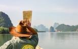 Longtail boat cruising through Phang Nga Bay limestone karsts