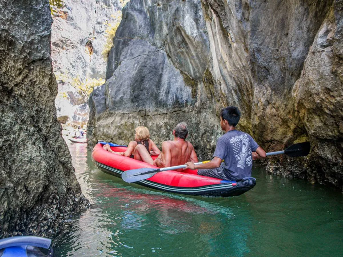 Canoe drifting through the calm green water of Phang Nga Bay