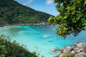 Turquoise bay with speedboats and granite boulders seen from a jungle viewpoint, Similan Islands, Thailand