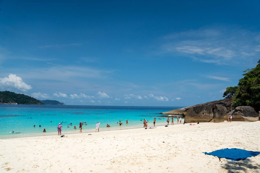 Puderweißer Sandstrand und türkisfarbenes Wasser unter blauem Himmel auf den Similan-Inseln, Andamanensee