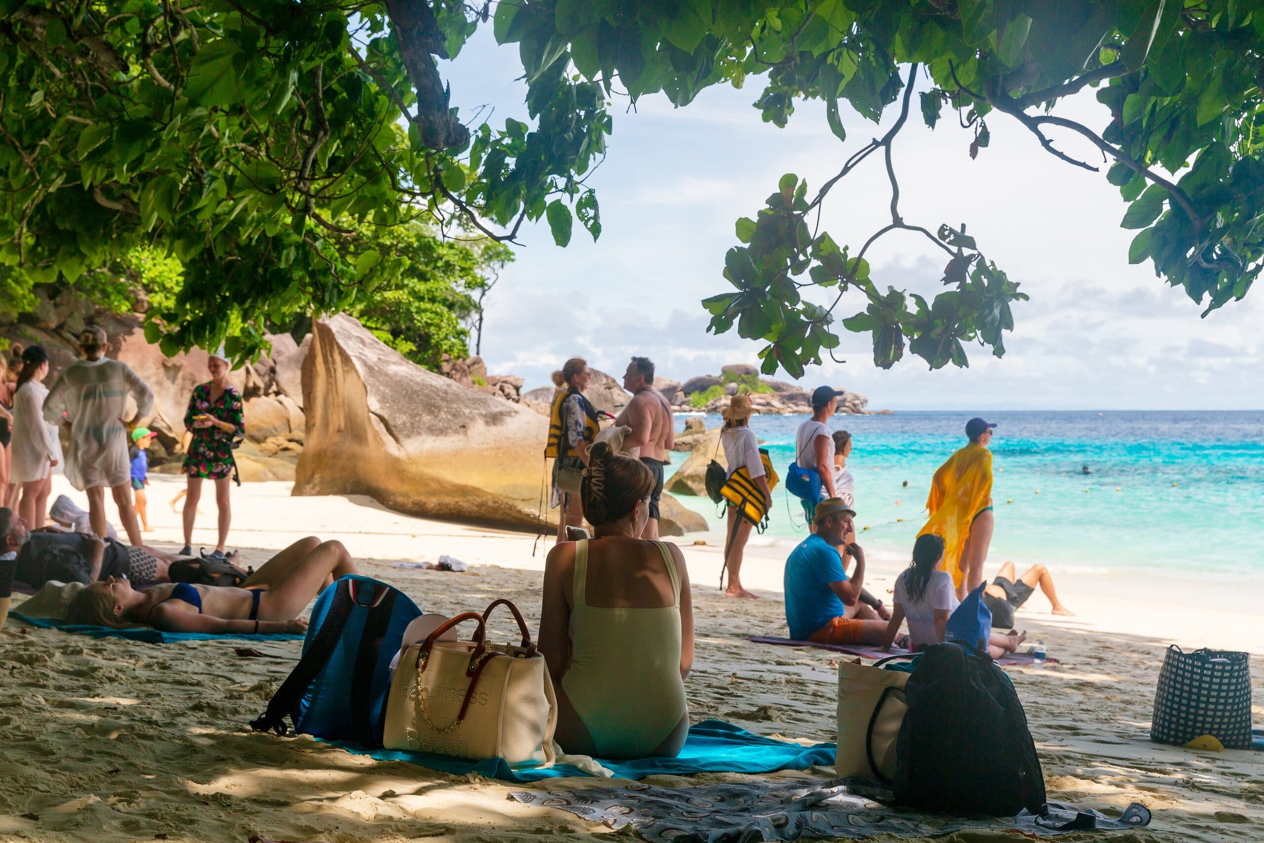 Guests relaxing in the shade on the white-sand beach of Similan Island No. 4 after the picnic lunch
