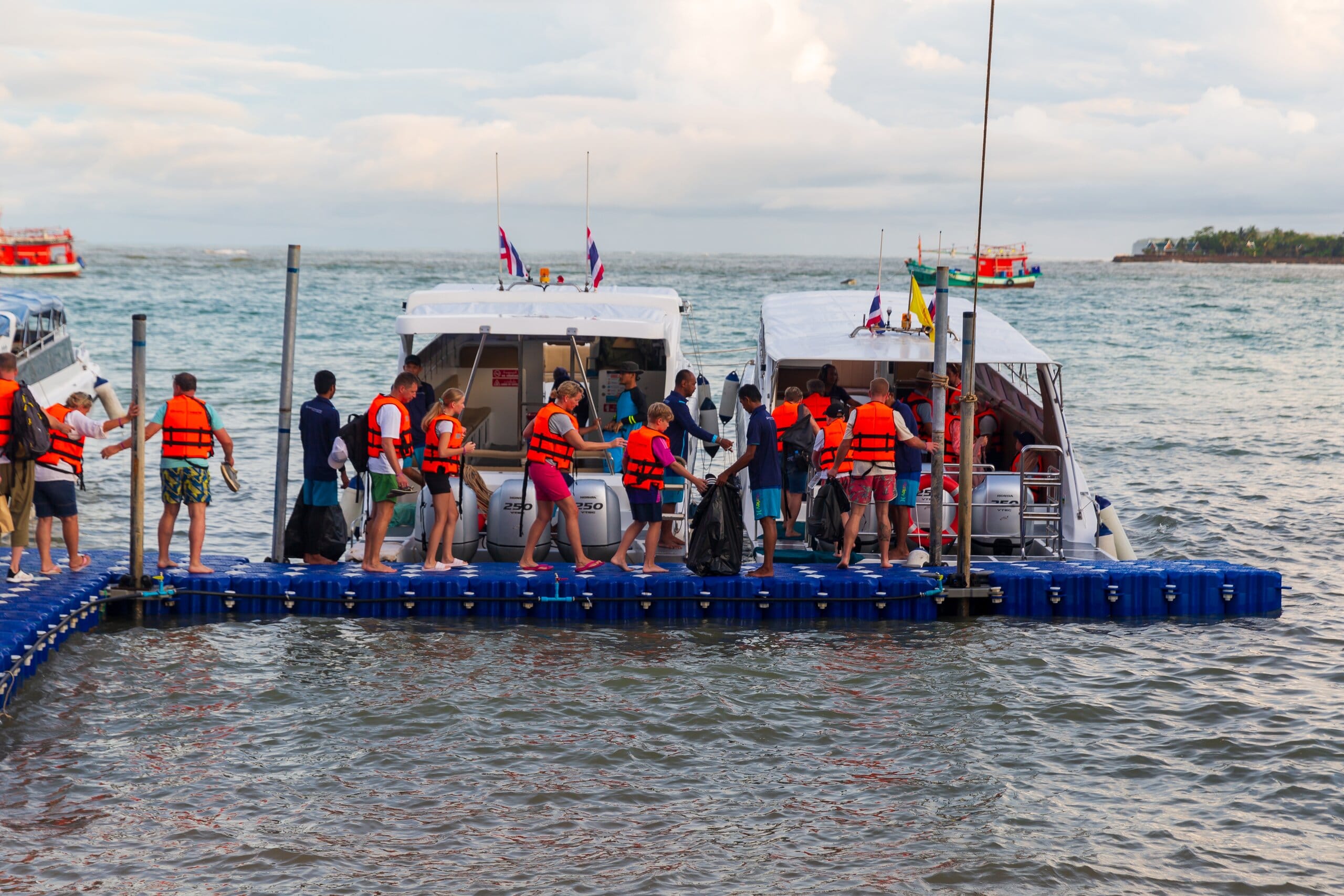 Khao Lak Land Discovery speedboats moored at the floating pier as guests in life vests board for the Similan Islands