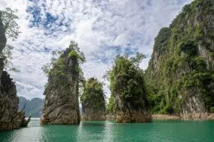 Limestone karst pillars rising from the emerald water of Cheow Lan Lake, Khao Sok National Park