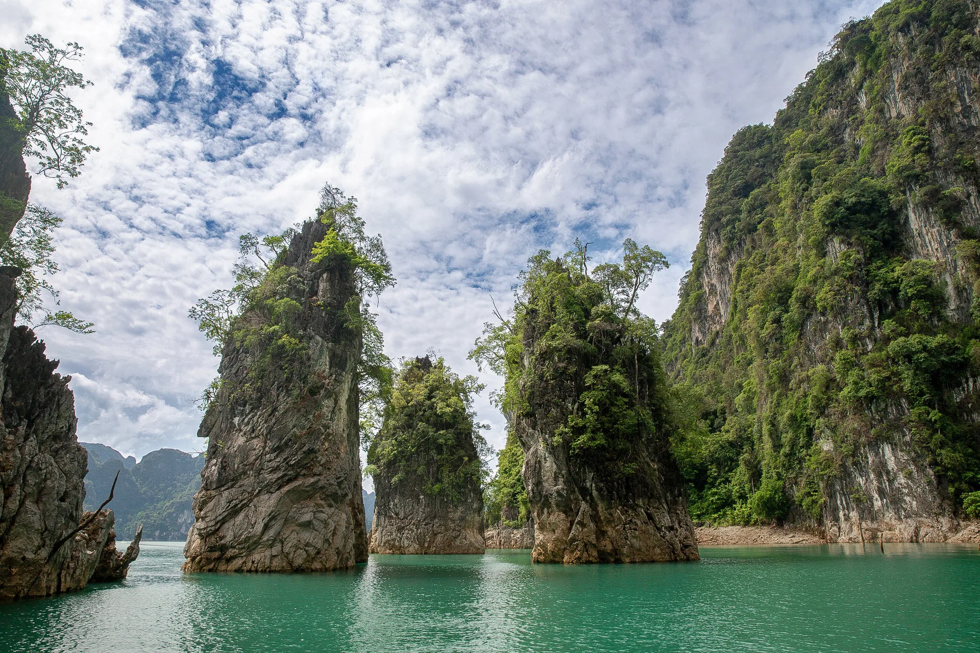 Kalksteinkarstsäulen ragen aus dem smaragdgrünen Wasser des Cheow-Lan-Sees, Khao-Sok-Nationalpark