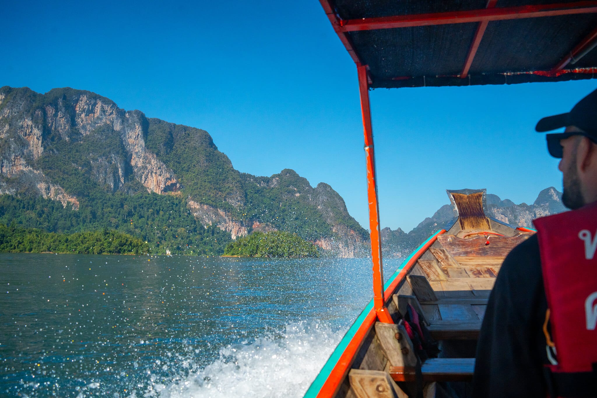 View from a longtail boat speeding across Cheow Lan Lake toward limestone mountains, Khao Sok