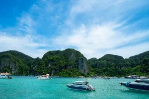 Speedboats anchored in a turquoise bay off the Phi Phi Islands under a bright blue sky