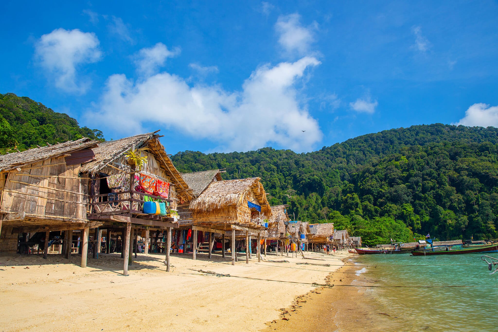 Thatched stilt houses of the Moken village along a sandy beach on the Surin Islands, Phang Nga