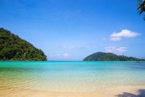 Calm turquoise bay between green islands under a blue sky at Mu Ko Surin National Park, Thailand