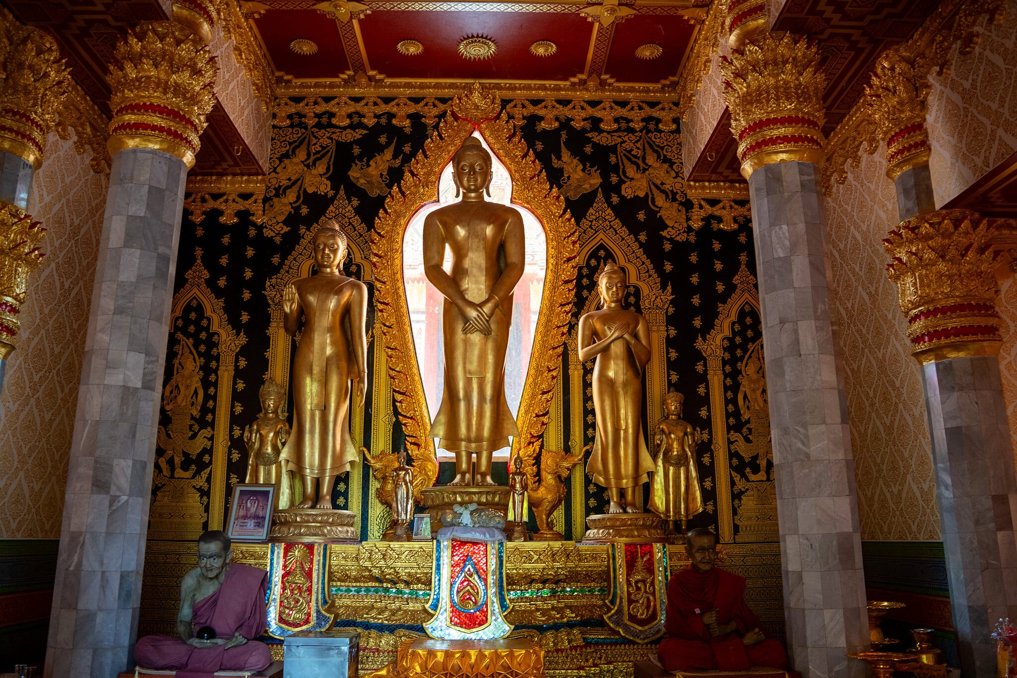 Golden standing Buddha statues inside the ordination hall at Wat Bang Riang, Phang Nga