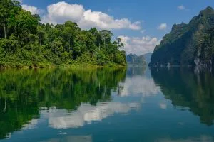 Jungle islands and clouds mirrored in the calm water of Cheow Lan Lake, Khao Sok National Park