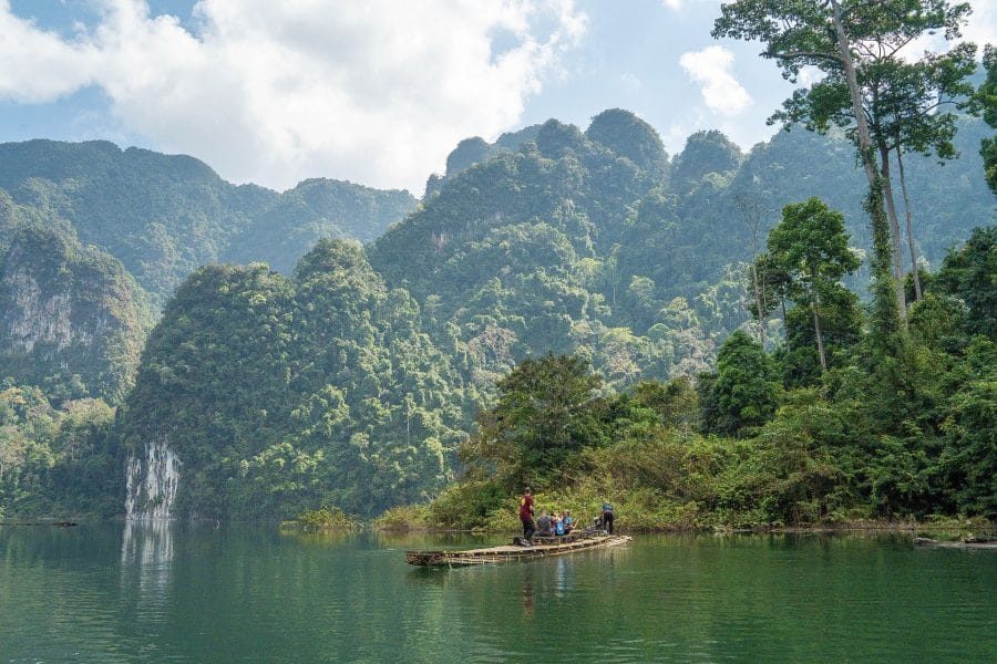 Bamboo raft beneath jungle-clad karst cliffs on Cheow Lan Lake, Khao Sok National Park