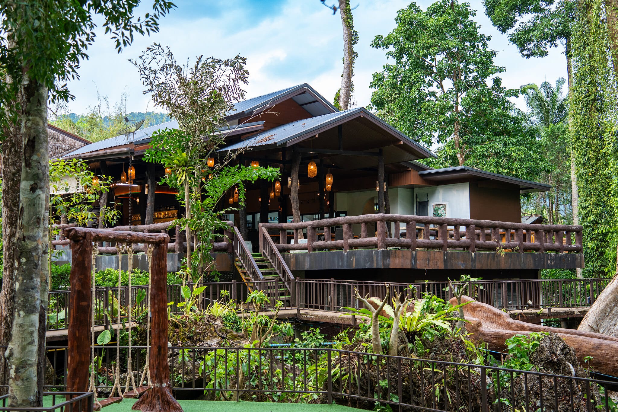 Hölzerne Lodge im Baumhausstil zwischen Regenwaldbäumen in Khao Sok