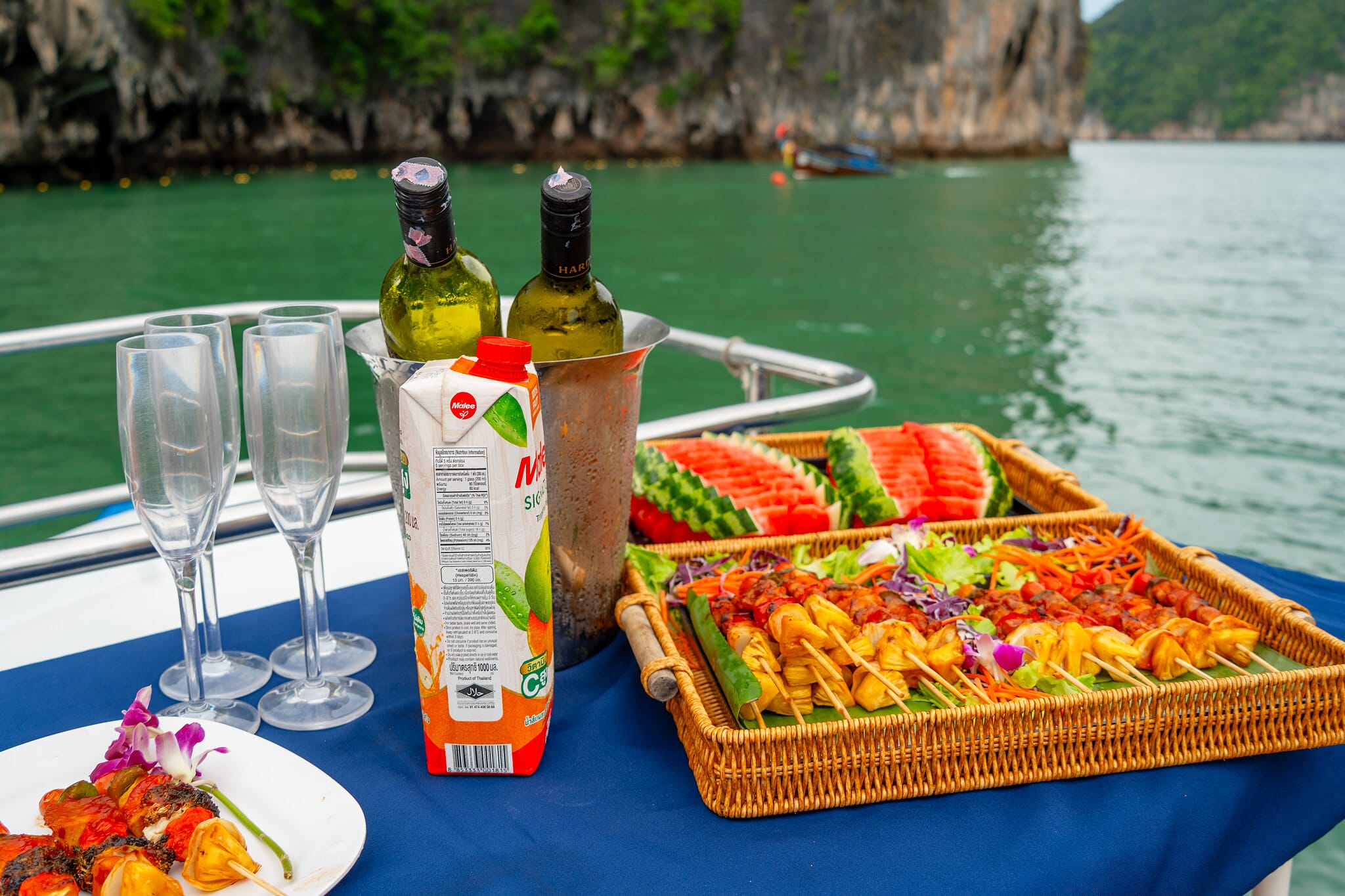 Frisches Obst, Grillspieße und Getränke an Deck bei der Sonnenuntergangsfahrt in der Phang-Nga-Bucht