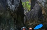 Boat passing through a narrow limestone cave passage