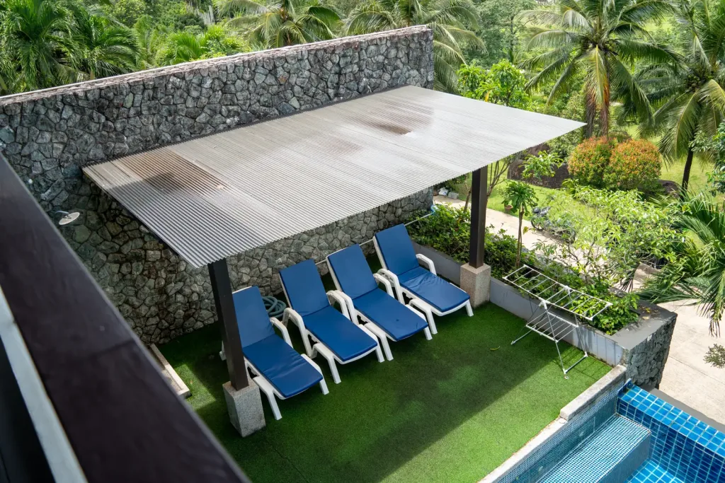 Sun loungers under a pergola by the pool at the Khao Lak villa