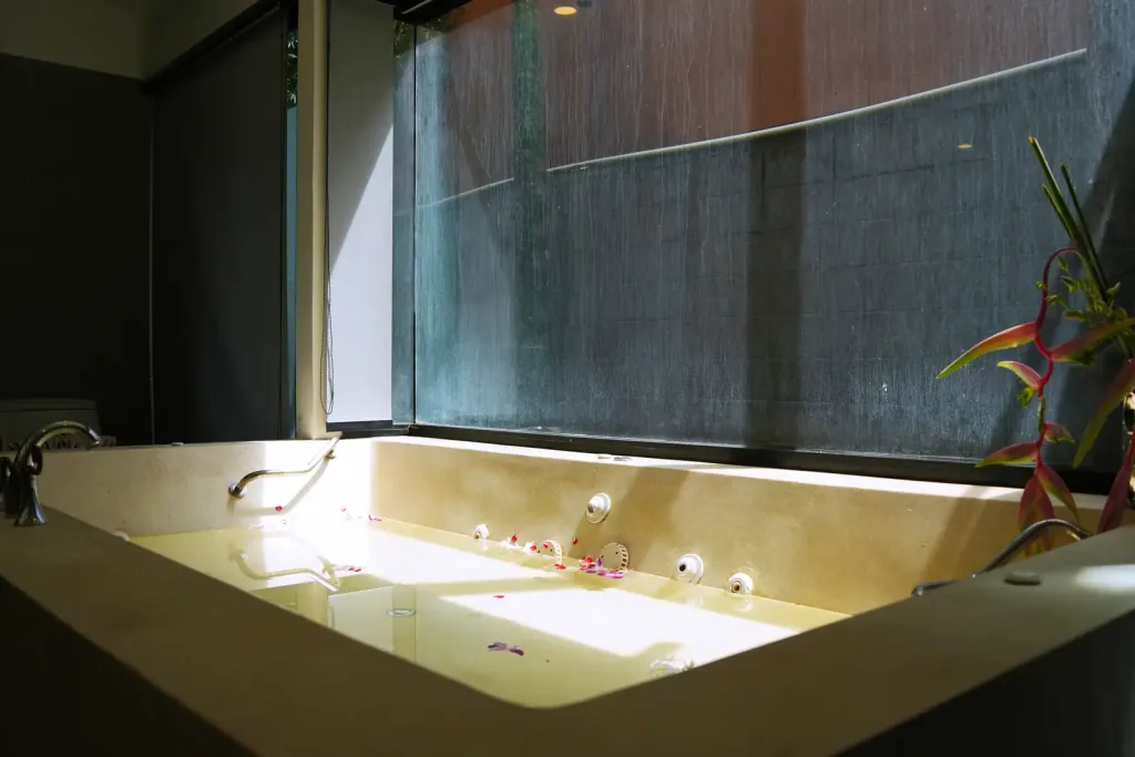 Corner spa bath with a tropical flower and petals