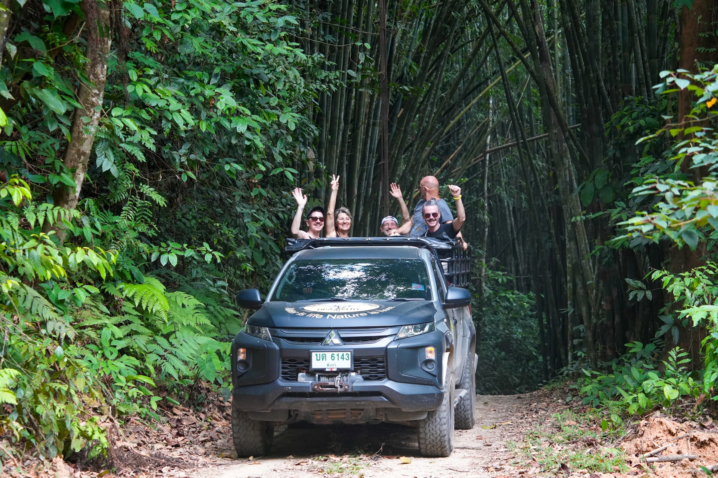 The off-road 4x4 climbs a dirt track through towering bamboo forest on the Khao Lak jungle safari