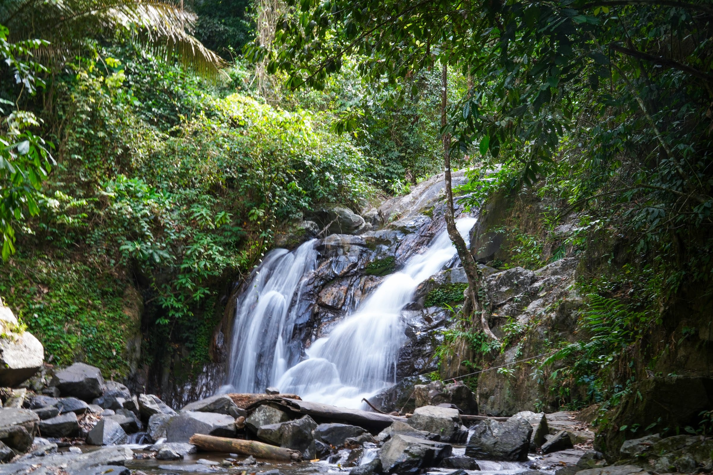 A secluded waterfall tumbles over mossy rocks deep in the rainforest visited on the Khao Lak off-road safari