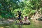 Guests drift downstream on a traditional bamboo raft through dense jungle on the Khao Lak safari tour
