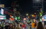 Crowds fill Bangla Road beneath a wall of neon signs on a Patong nightlife evening in Phuket