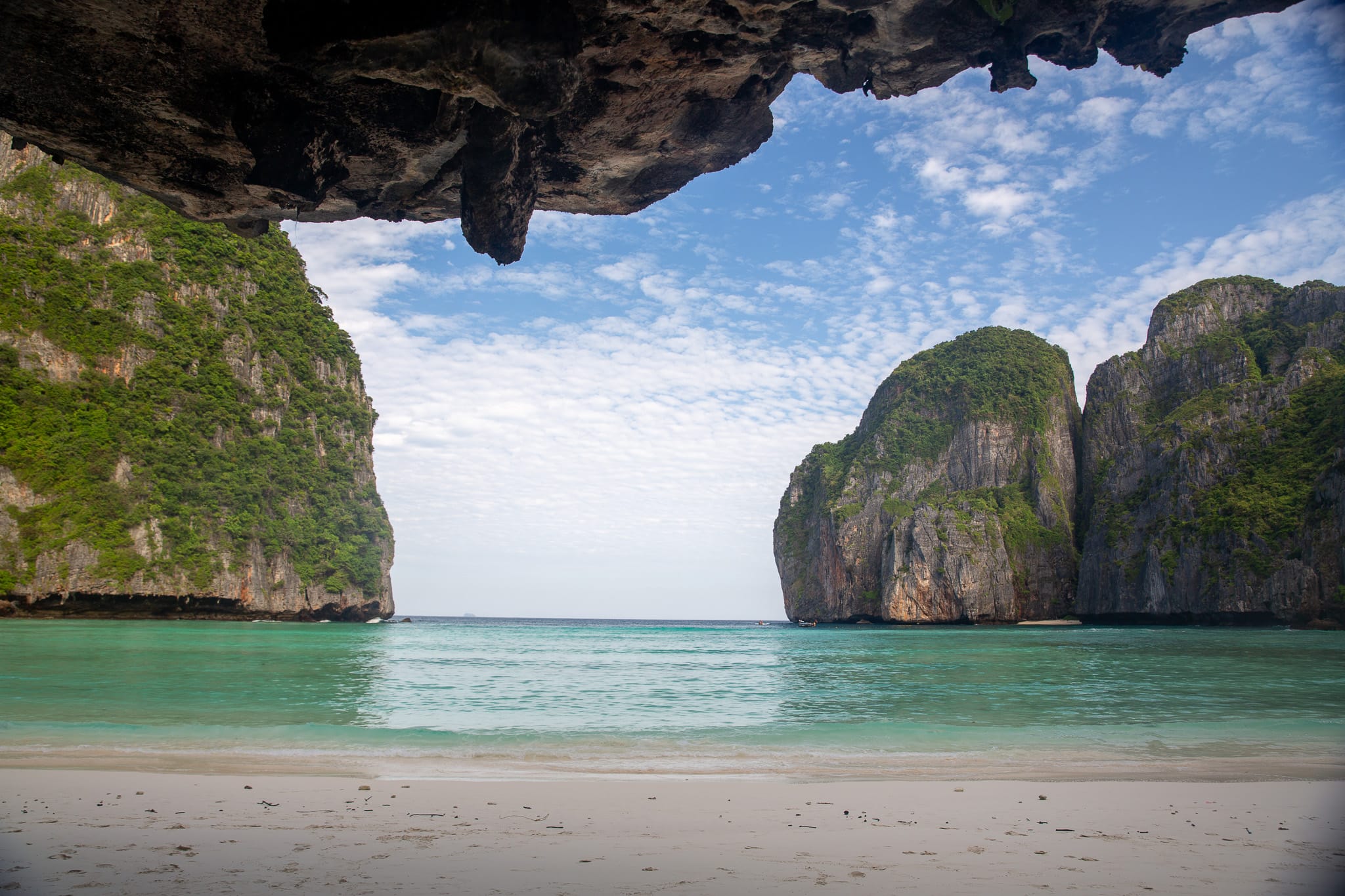 View through a natural rock arch to the limestone karsts and calm sea at Phi Phi Leh.