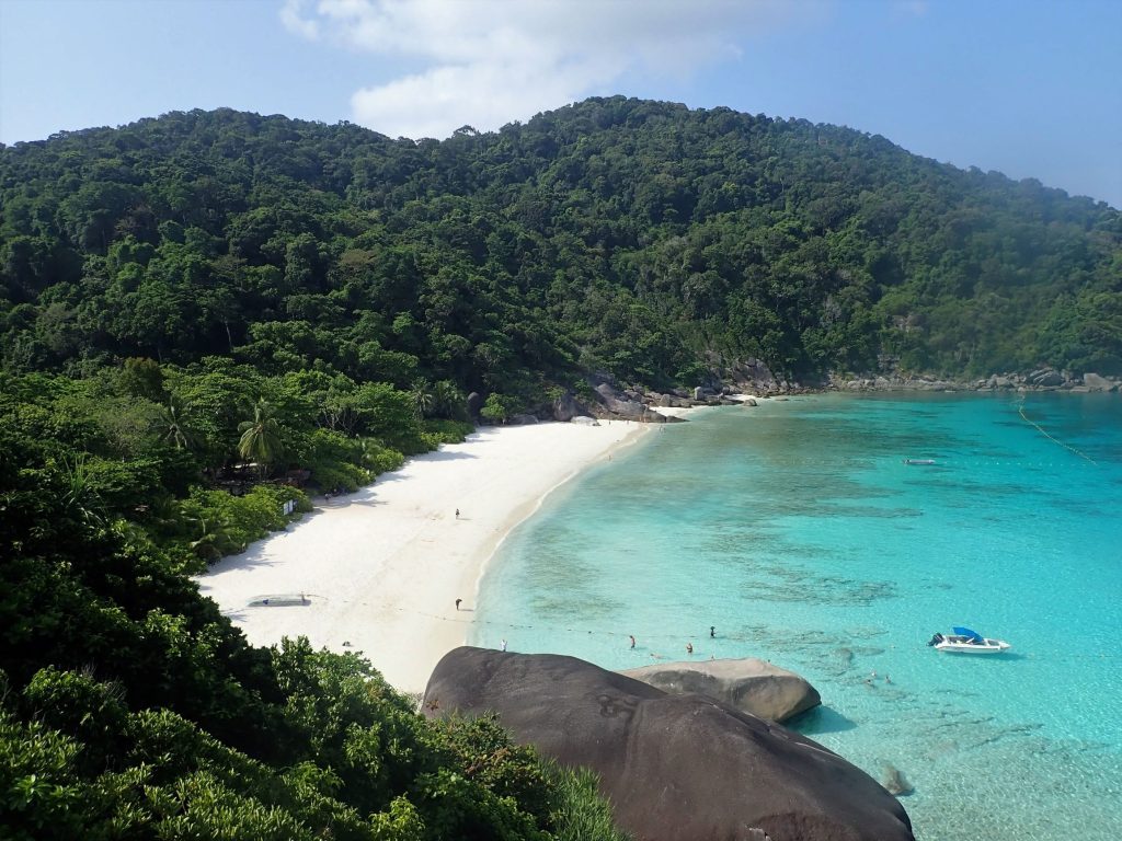 Similan Islands bay seen from a viewpoint, with a snorkeling boat moored off the beach