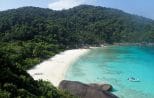 Similan Islands bay seen from a viewpoint, with a snorkeling boat moored off the beach