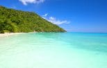 Wide turquoise bay and white sand beach backed by jungle in the Similan Islands