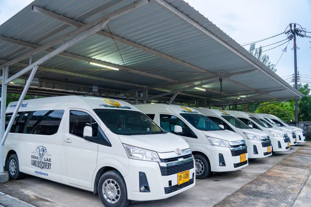 Khao Lak Land Discovery'S White Toyota Commuter Vans For Private Transfers, Parked Under The Company Carport